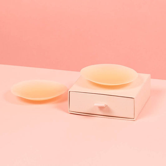 Beige nipple covers resting on a pink Brelese box